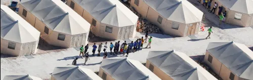 Immigrant children now housed in a tent encampment under the new "zero tolerance" policy by the Trump administration are shown walking in single file at the facility near the Mexican border in Tornillo, Texas, U.S. June 19, 2018.        REUTERS/Mike Blake - RC187D98B970