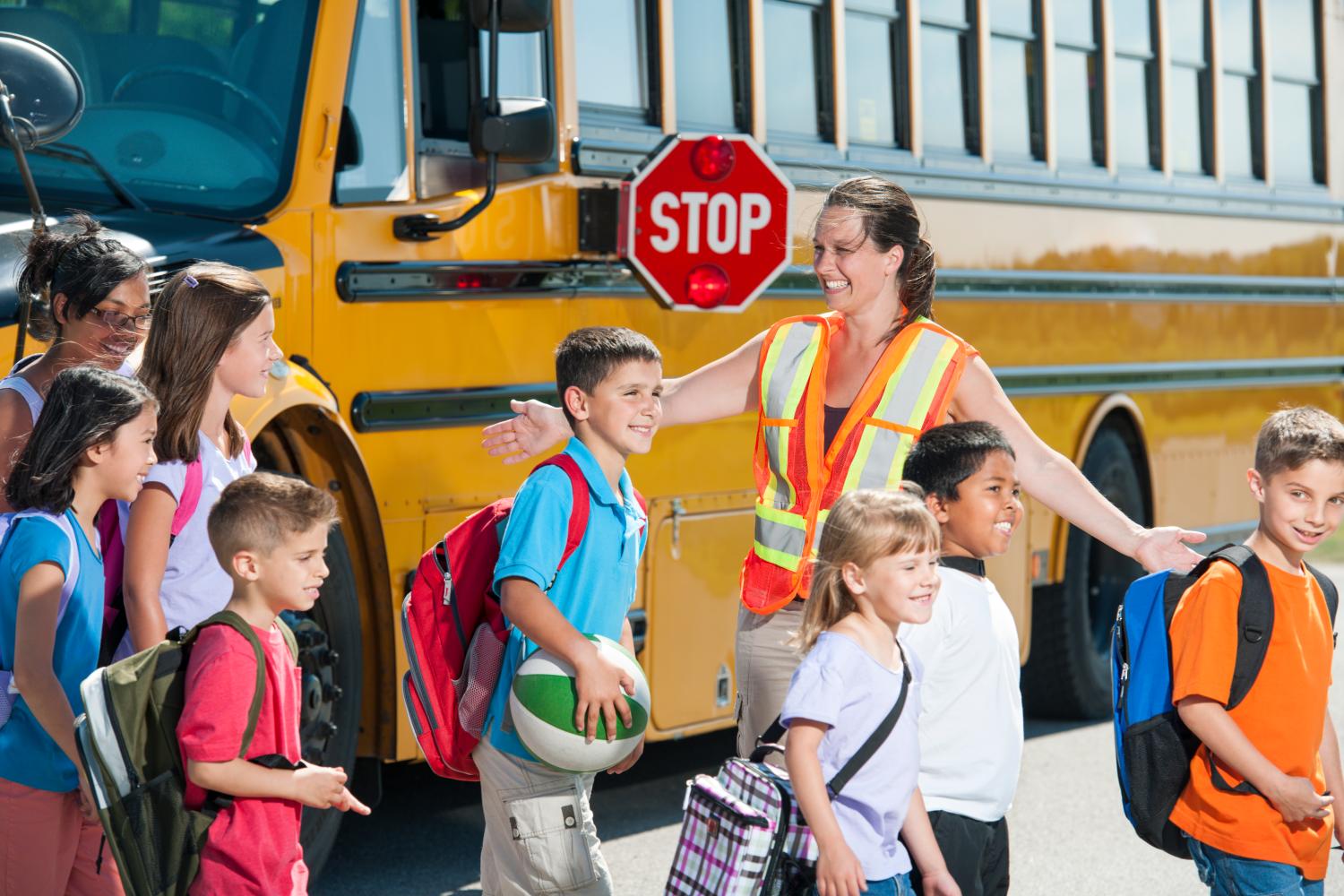 Children getting off the bus at the cross walk.