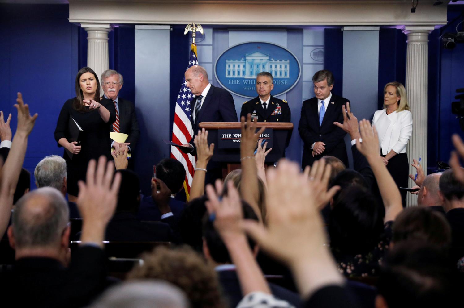 White House Press Secretary Sarah Huckabee Sanders points to questioners as National Security Advisor John Bolton, U.S. Director of National Intelligence Dan Coats, National Security Agency (NSA) Director General Paul Nakasone, FBI Director Christopher Wray and Department of Homeland Security (DHS) Secretary Kirstjen Nielsen hold a briefing on election security in the White House press briefing room at the White House in Washington, U.S., August 2, 2018.  REUTERS/Carlos Barria      TPX IMAGES OF THE DAY - RC1CC3F64980