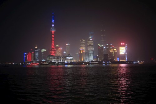 Shanghai's landmark building Oriental Pearl TV Tower is lit up in blue, white and red, the colors of the French flag, following the Paris attacks, in Shanghai, China, November 14, 2015. REUTERS/Aly Song - GF20000059181