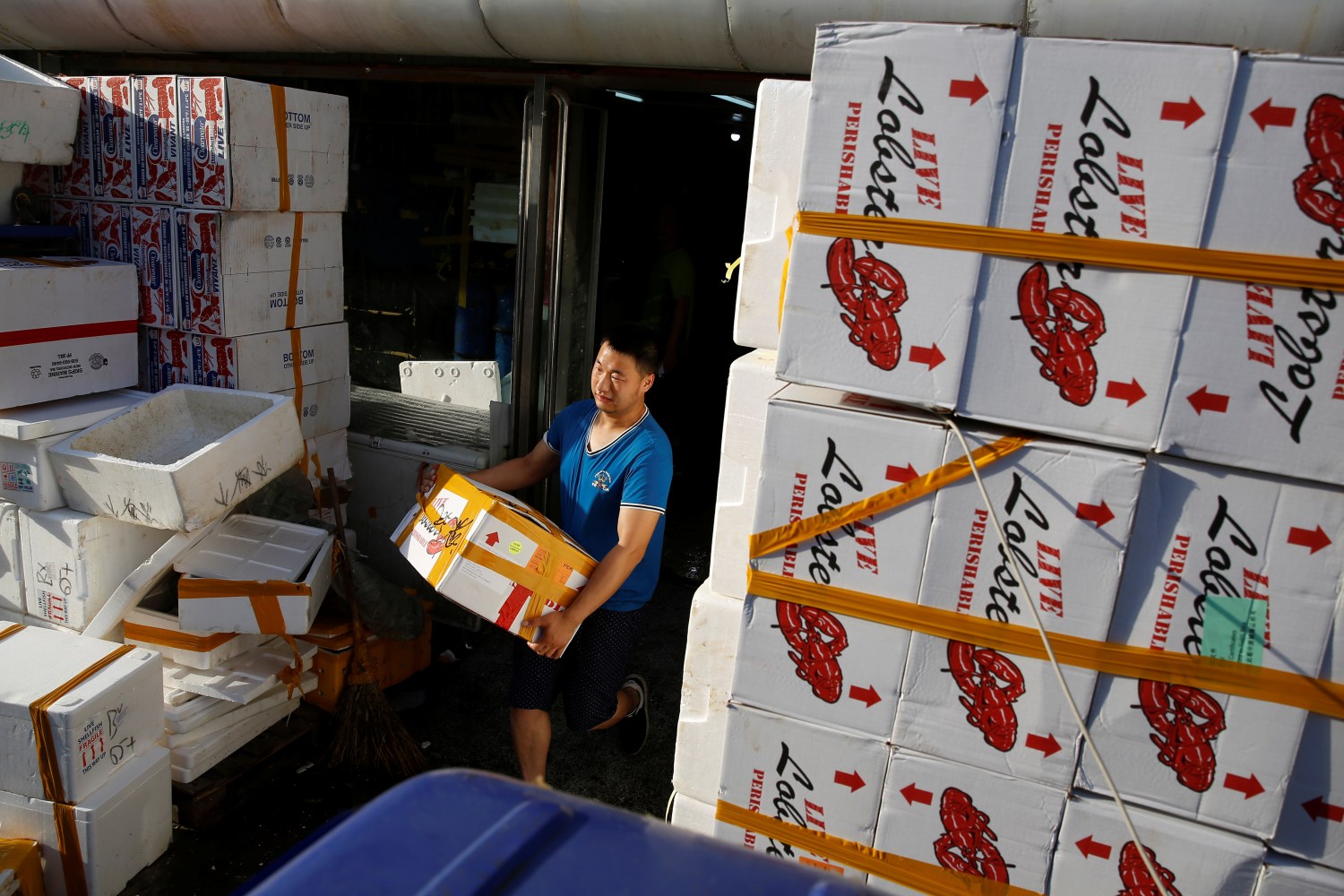 A customer carries a box of lobsters that are imported from the U.S. at a seafood retailer at a fish market in Beijing, China, June 27, 2018. Picture taken June 27, 2018.  REUTERS/Thomas Peter - RC1C6923C110
