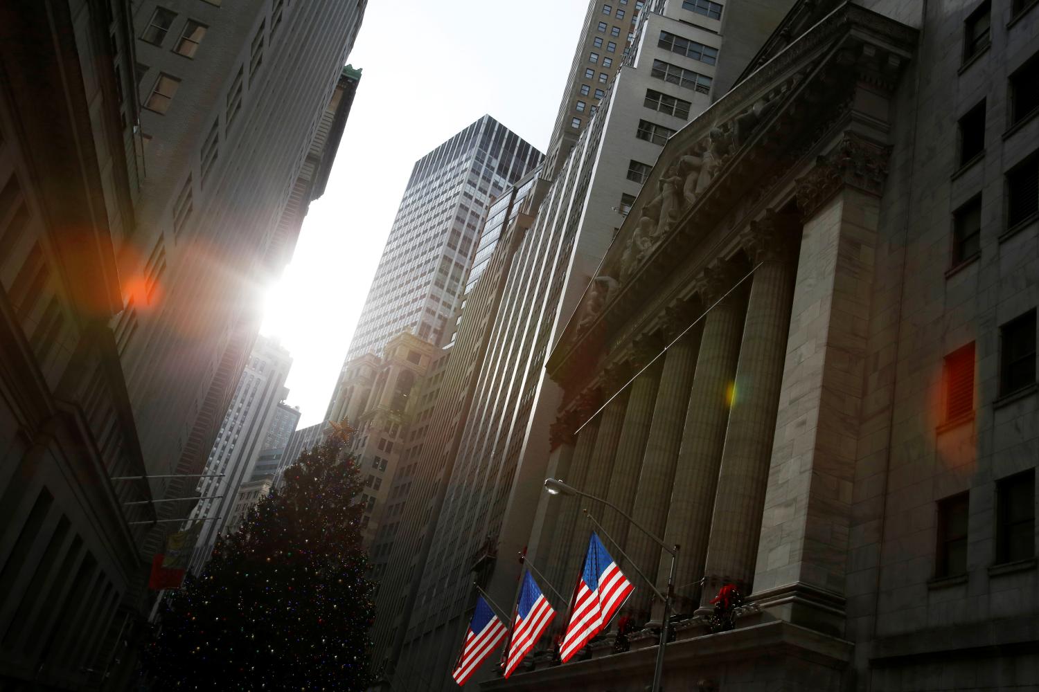 U.S. flags hang at the New York Stock Exchange in Manhattan, New York City, U.S., December 21, 2016. REUTERS/Andrew Kelly - RC166FFF9250