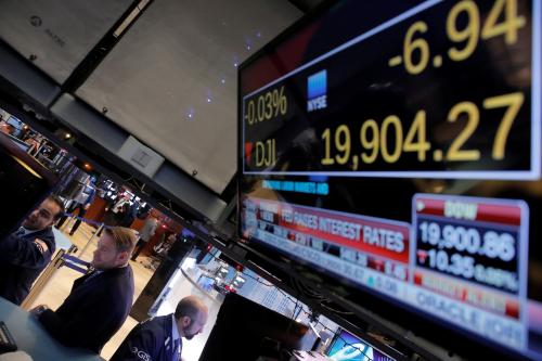 Traders work on the floor of the New York Stock Exchange (NYSE) as a television screen shows news of the announcement that the U.S. Federal Reserve will hike interest rates in New York, U.S., December 14, 2016.  REUTERS/Lucas Jackson - RC1E038D4870