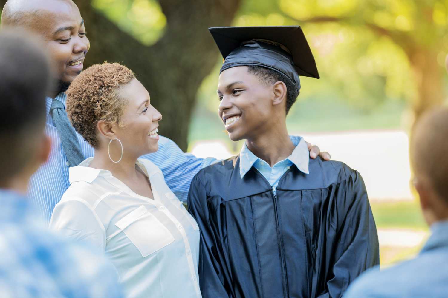 Male high school graduate smiles at his proud mom.