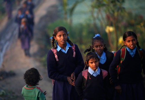 Schoolgirls make their way to their school through a vegetable field early morning in New Delhi December 11, 2013. REUTERS/Ahmad Masood (INDIA - Tags: SOCIETY EDUCATION) - GM1E9CB169K01