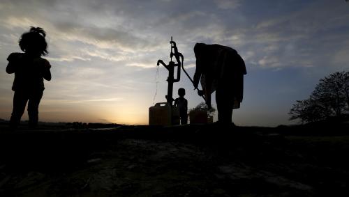 A woman draws water from a well in a slum on the outskirts of Islamabad March 30, 2015. REUTERS/Caren Firouz - GF10000043990