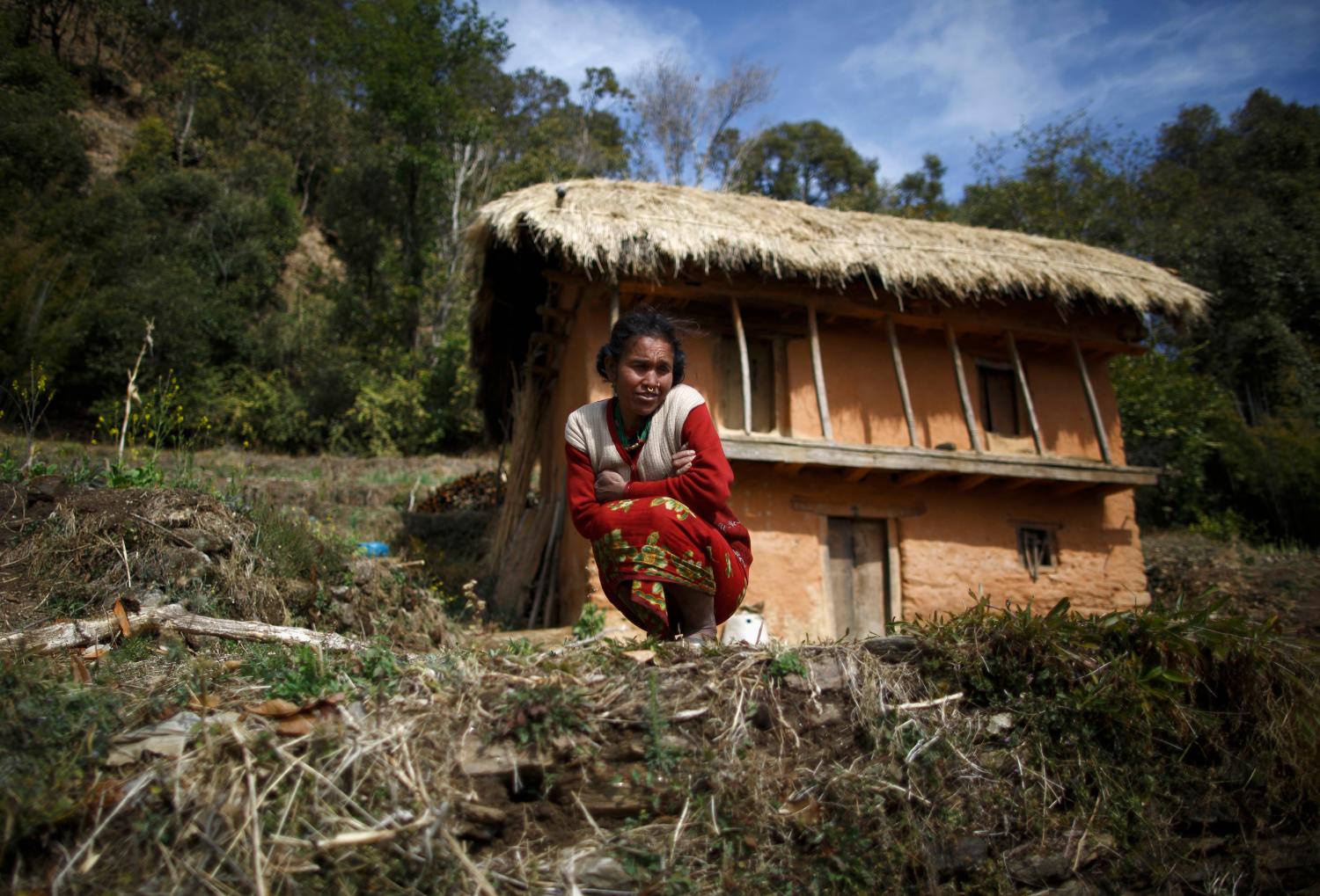 Jamuna Devi Saud, 45, sits outside her house while practicing Chaupadi in the hills of Legudsen village in Achham District in western Nepal February 16, 2014. Chaupadi is a tradition observed in parts of Nepal, which cuts women off from the rest of society when they are menstruating. Women who practice traditional chaupadi have to sleep in sheds or outbuildings while they are on their period, often with little protection from the elements. They are not allowed to enter houses or temples, use normal public water sources, take part in festivals or touch others during their menstruation, according to a United Nations field bulletin on the issue. Isolated in sheds that are frequently rickety and unhygienic, there have been cases of women dying while practicing chaupadi from illness, exposure, animal attacks or from fires lit in poorly ventilated spaces. Chaupadi was banned by Nepal's Supreme Court in 2005, but it is still common in the country's far and mid-western regions. Picture taken February 16, 2014. REUTERS/Navesh Chitrakar (NEPAL - Tags: SOCIETY)ATTENTION EDITORS: PICTURE 18 OF 20 FOR PACKAGE 'BANISHED ONCE A MONTH' TO FIND ALL IMAGES SEARCH 'CHAUPADI' - GM1EA350LH601
