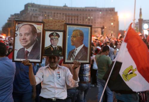 A man carries pictures of Egyptian army chief Abdel Fattah al-Sisi and late president Gamal Abdel-Nasser (R) as Egyptians gather in Tahrir square to celebrate al-Sisi's victory in presidential vote in Cairo, June 3, 2014. Sisi won 96.91 percent in a presidential vote last week, the election commission said on Tuesday, confirming interim results that had given him a landslide victory.REUTERS/Asmaa Waguih (EGYPT - Tags: POLITICS) - GM1EA6409EM01