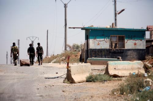 Syrian army soldiers walk along a street in Umm al-Mayazen, in the countryside of Deraa, Syria, July 10, 2018. REUTERS/Omar Sanadiki - RC1740AD63D0