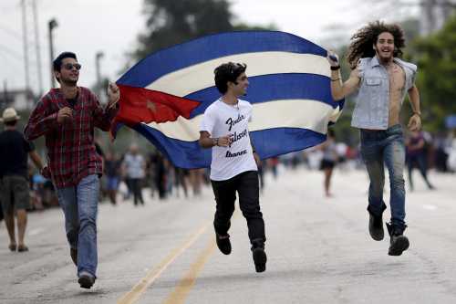 Fans run with a Cuban flag outside Ciudad Deportiva de la Habana sports complex where the Rolling Stones' free outdoor concert will take place today in Havana, March 25, 2016. REUTERS/Ueslei Marcelino      TPX IMAGES OF THE DAY      - GF10000360577