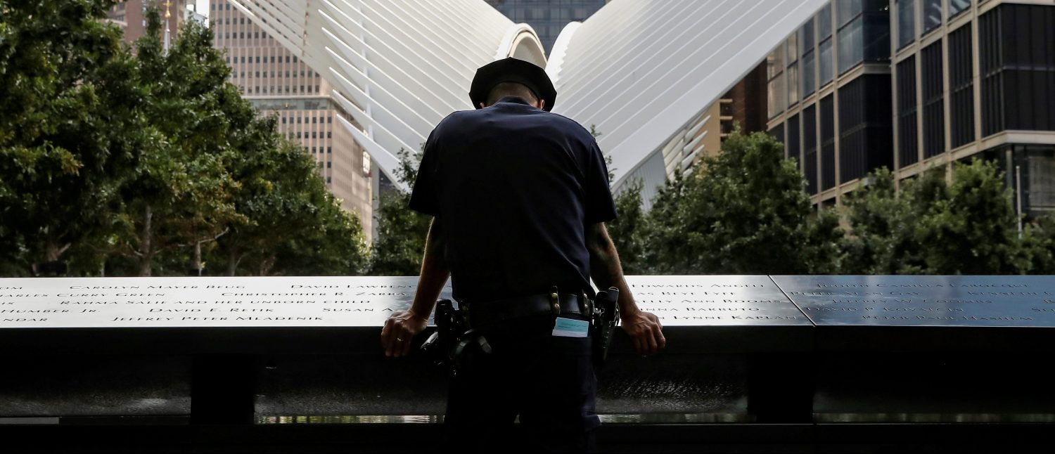 A New York City Police Department (NYPD) officer pauses at the edge of the reflecting pool at the National 9/11 Memorial and Museum during ceremonies marking the 16th anniversary of the attacks in New York, U.S., September 11, 2017. REUTERS/Brendan McDermid     TPX IMAGES OF THE DAY - RC191F4FEB50