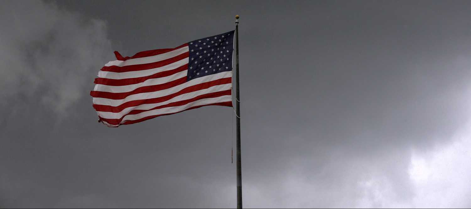 Storm clouds loom over an American flag in Convent, Louisiana, U.S., June 11, 2018. Picture taken June 11, 2018. REUTERS/Jonathan Bachman - RC17A0081E00