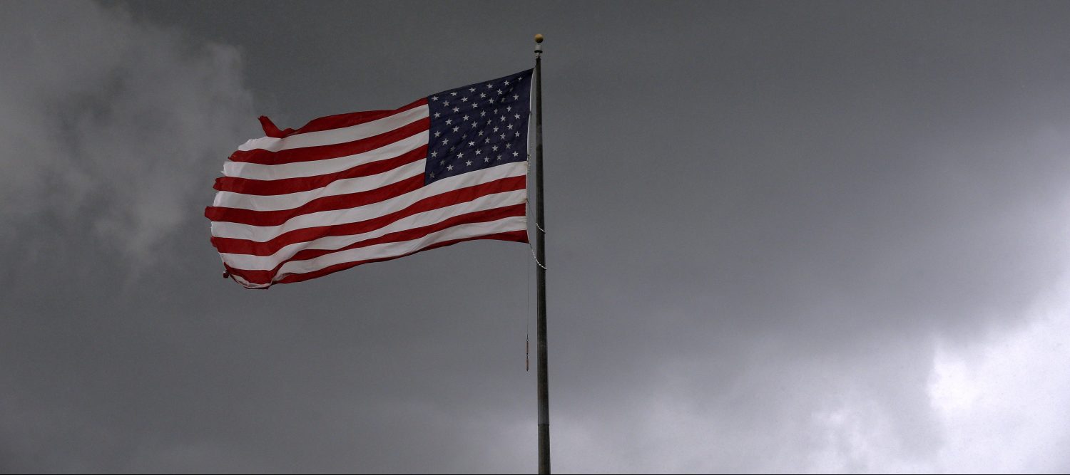 Storm clouds loom over an American flag in Convent, Louisiana, U.S., June 11, 2018. Picture taken June 11, 2018. REUTERS/Jonathan Bachman - RC17A0081E00