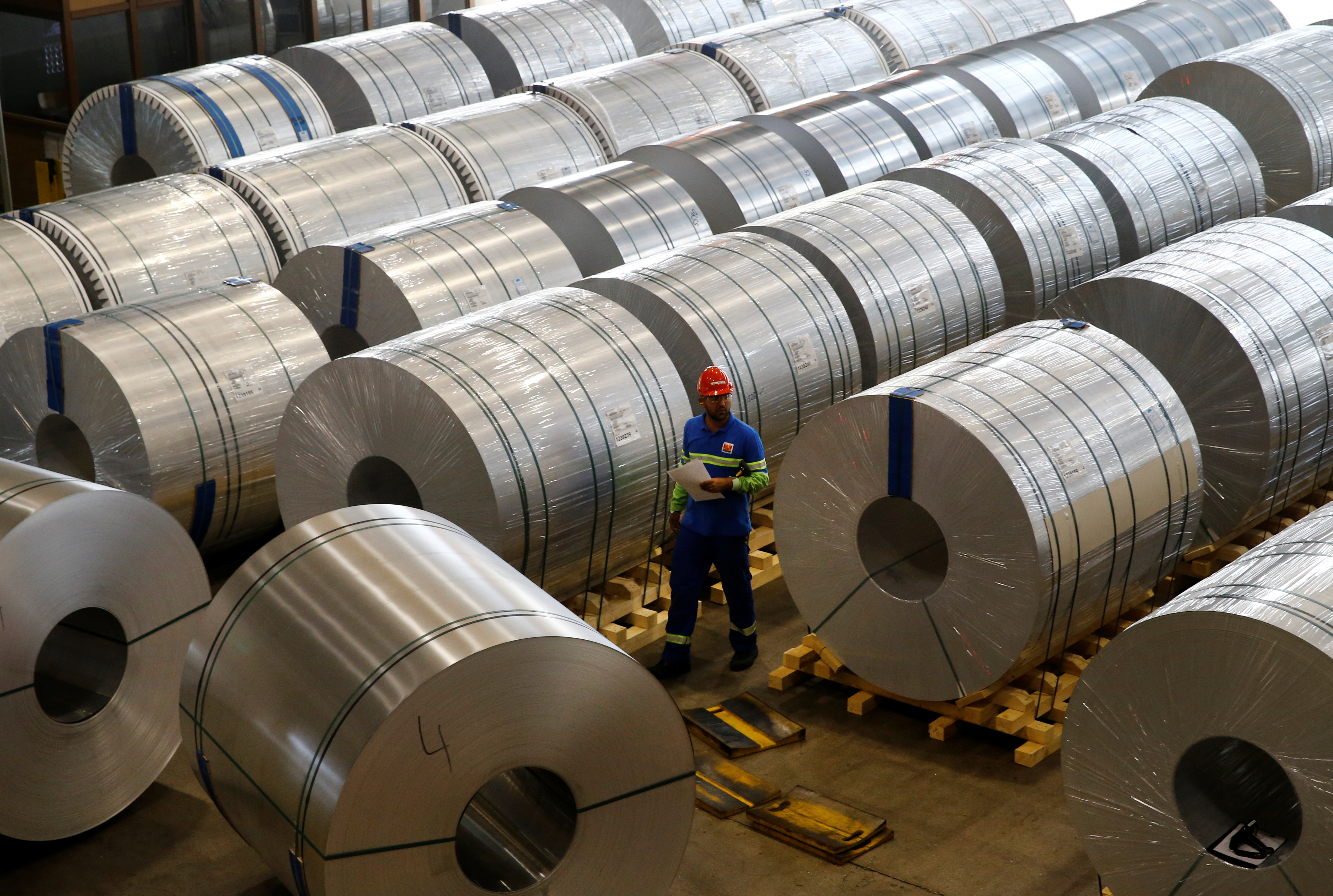 A staff checks finished aluminum coils at the facility of flat-rolled aluminum products maker Novelis, part of Aditya Birla Group, in Sierre, Switzerland, September 12, 2018. Picture taken September 12, 2018.  REUTERS/Denis Balibouse - RC1DF02E1A80