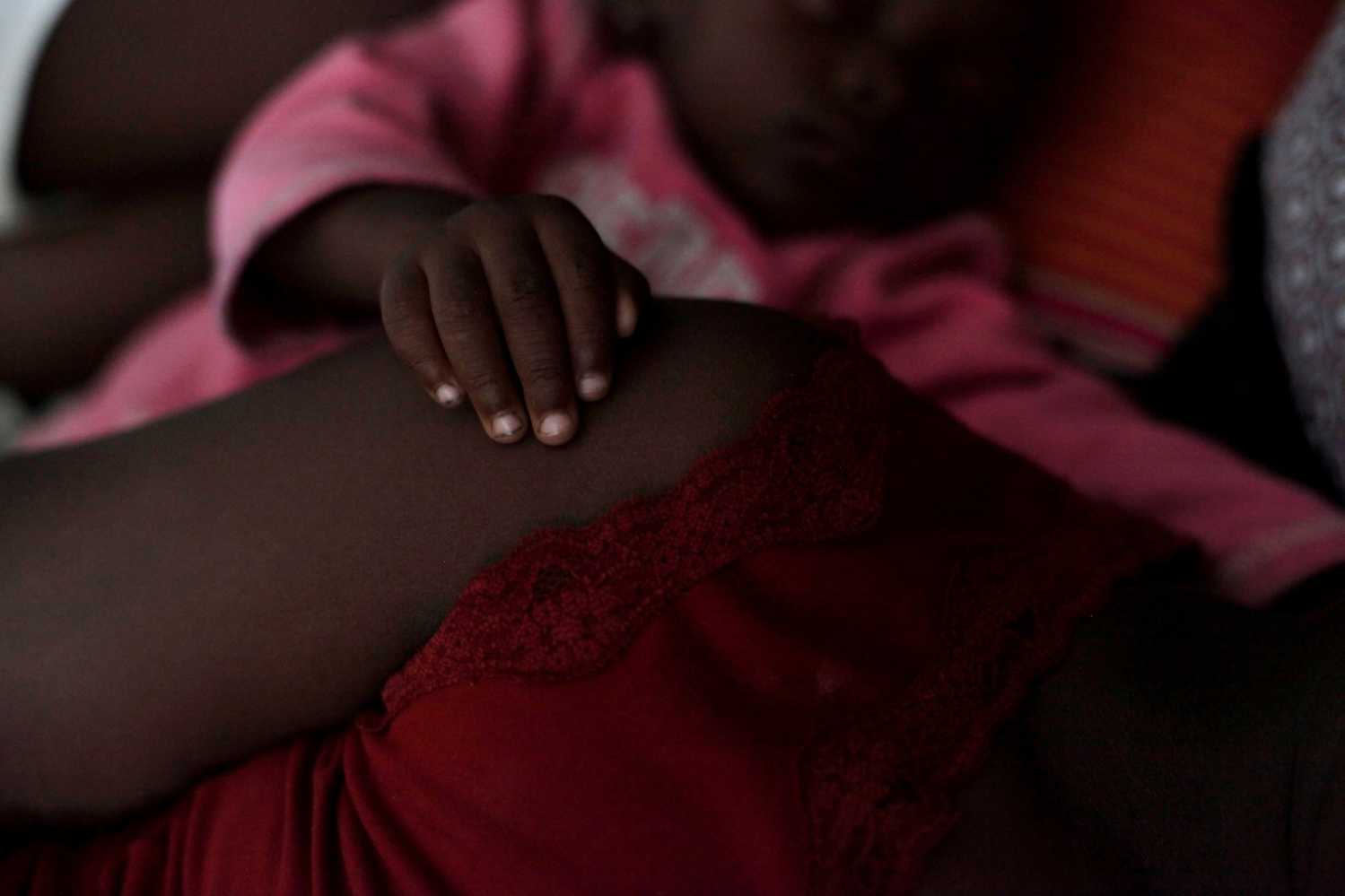 A baby touches her mother's shoulder as they rest at the shelter set up in the Lycee Philippe Guerrier ahead of Hurricane Matthew in Les Cayes, Haiti, October 3, 2016. REUTERS/Andres Martinez Casares - S1BEUEWVDMAA