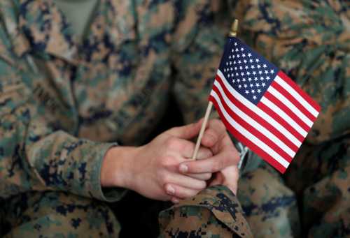 A soldier holds a flag as U.S. President Donald Trump speaks at Marine Corps Air Station Miramar in San Diego, California, U.S. March 13, 2018. REUTERS/Kevin Lamarque - RC1E9090D5E0