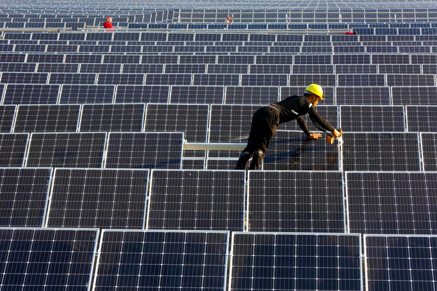 A man works on solar panels at a solar power plant of China Huaneng Group in Huaiyin, Jiangsu province, China June 13, 2018.  REUTERS/Stringer ATTENTION EDITORS - THIS IMAGE WAS PROVIDED BY A THIRD PARTY. CHINA OUT. - RC135BDD6120