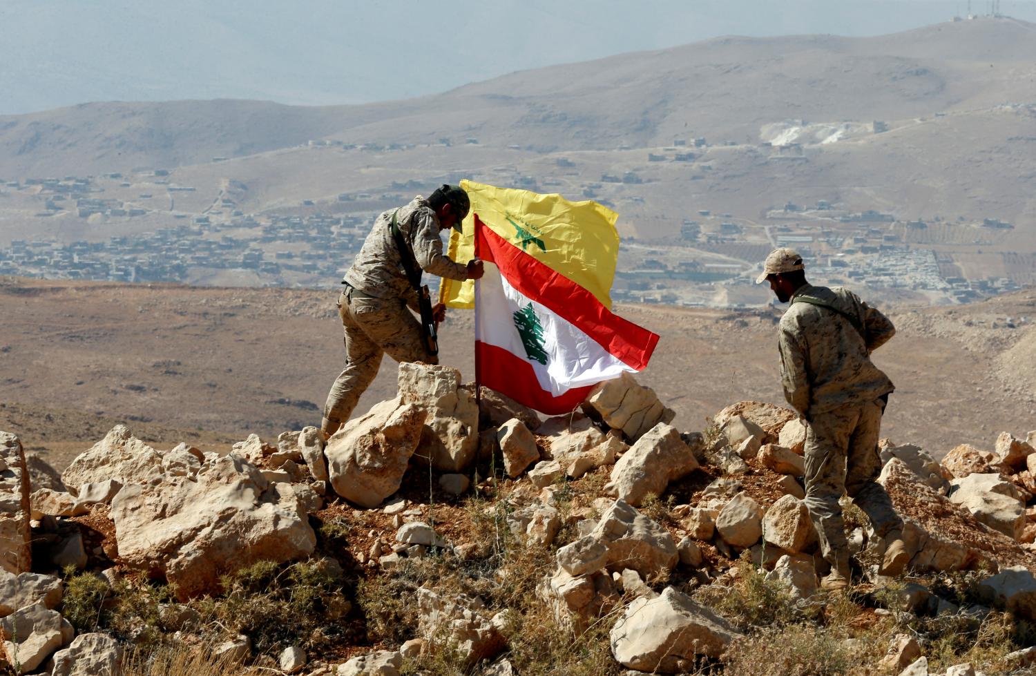 Hezbollah fighters put Lebanese and Hezbollah flags at Juroud Arsal, Syria-Lebanon border, July 25, 2017. Picture taken July 25, 2017. REUTERS/Mohamed Azakir     TPX IMAGES OF THE DAY - RC11019C4D00