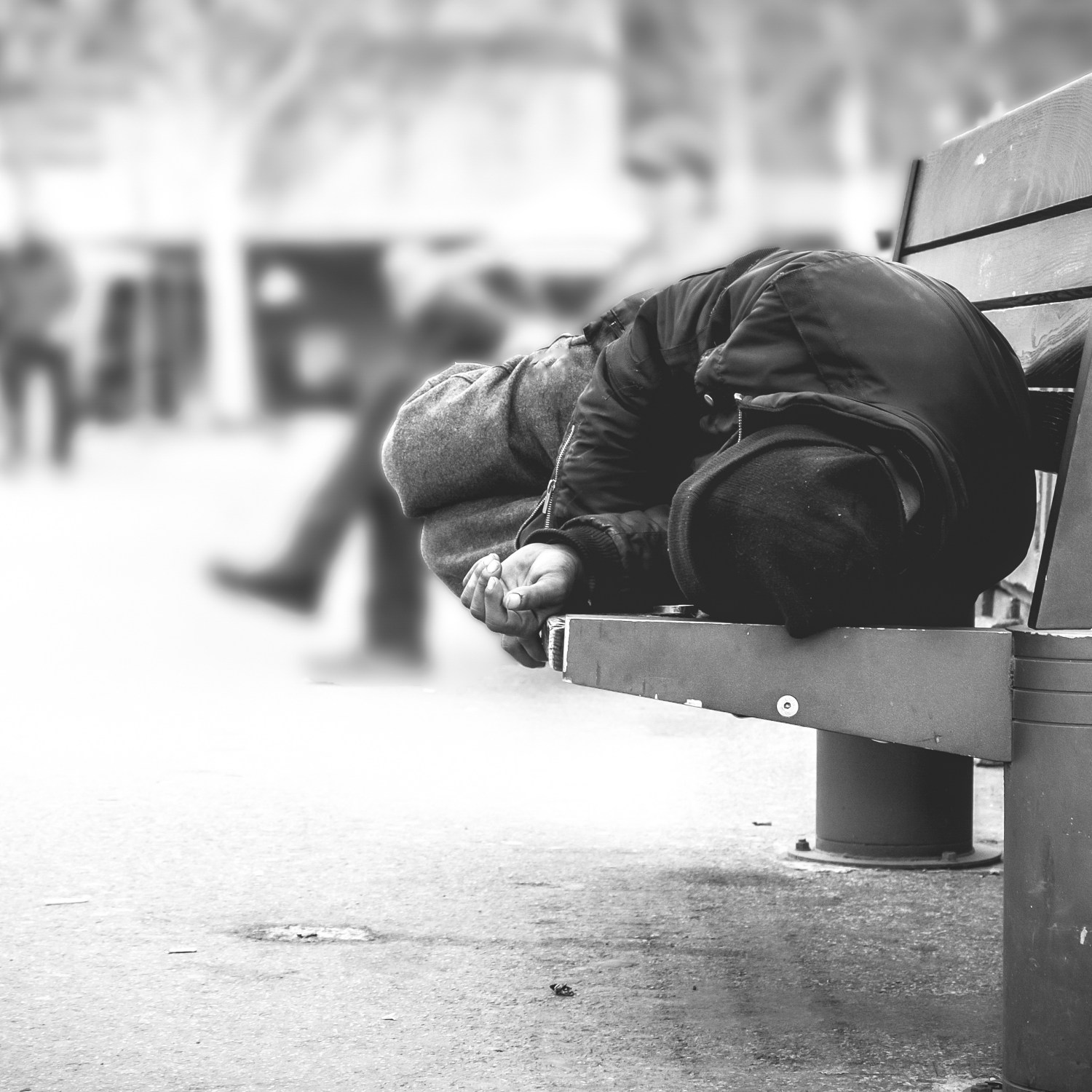 homeless person laying on bench