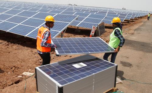 Workers carry photovoltaic solar panels for installation at the Gujarat solar park under construction in Charanka village in Patan district of the western Indian state of Gujarat April 14, 2012. According to officials, the solar park is the largest in India which will generate 210 megawatts and will be operational from April 19, 2012. REUTERS/Amit Dave (INDIA - Tags: BUSINESS ENERGY) - GM1E84E1P7C01