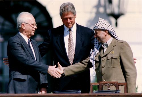 PLO Chairman Yasser Arafat (R) shakes hands with Israeli Prime Minister Yitzhak Rabin (L), as U.S. President Bill Clinton stands between them, after the signing of the Israeli-PLO peace accord, at the White House in Washington September 13, 1993. REUTERS/Gary Hershorn (UNITED STATES - Tags: POLITICS) - GM1E99D1UCD01