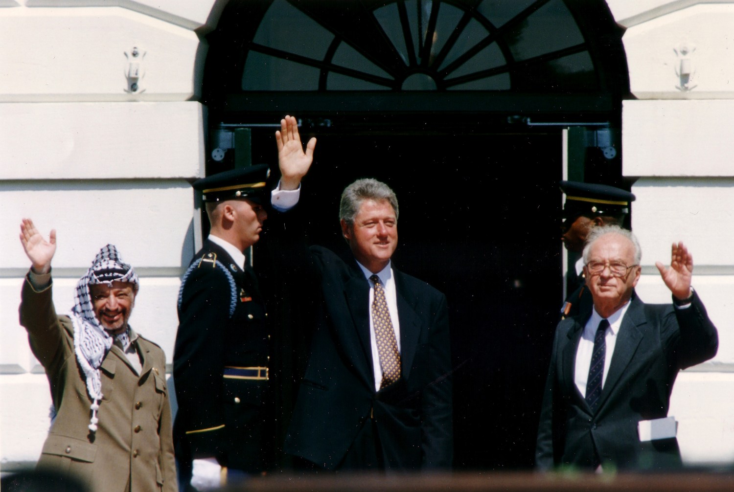 PLO Chairman Yasser Arafat (L) waves with Israeli Prime Minister Yitzhak Rabin (R) and U.S. President Bill Clinton after the signing of the Israeli-PLO peace accord, at the White House in Washington September 13, 1993. REUTERS/Gary Hershorn (UNITED STATES - Tags: POLITICS) - GM1E99E00KE01