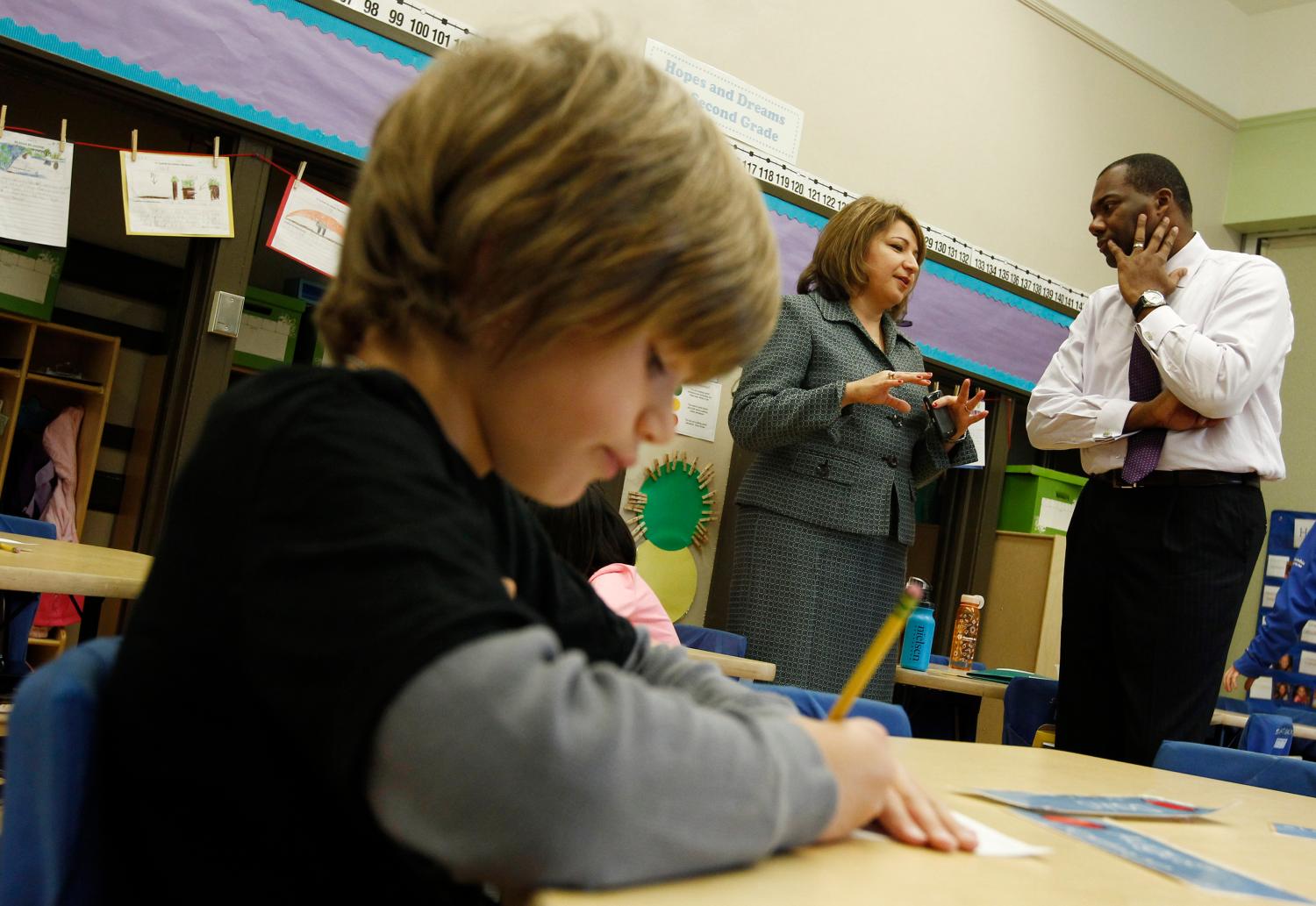 Chicago Public Schools CEO Jean-Claude Brizard (R) speaks with Disney II Elementary School principal Bogdana Chkoumbova (C) in Chicago, September 26, 2011. Disney is one of 13 Chicago public schools which have decided to be early adopters of a plan to add 90 minutes to the school day, a scheme pushed hard by new Mayor Rahm Emanuel who says it is necessary to improve the city's K-12 education. Picture taken September 26, 2011. REUTERS/Jim Young  (UNITED STATES - Tags: EDUCATION POLITICS SOCIETY BUSINESS EMPLOYMENT) - GM1E79T05FP01