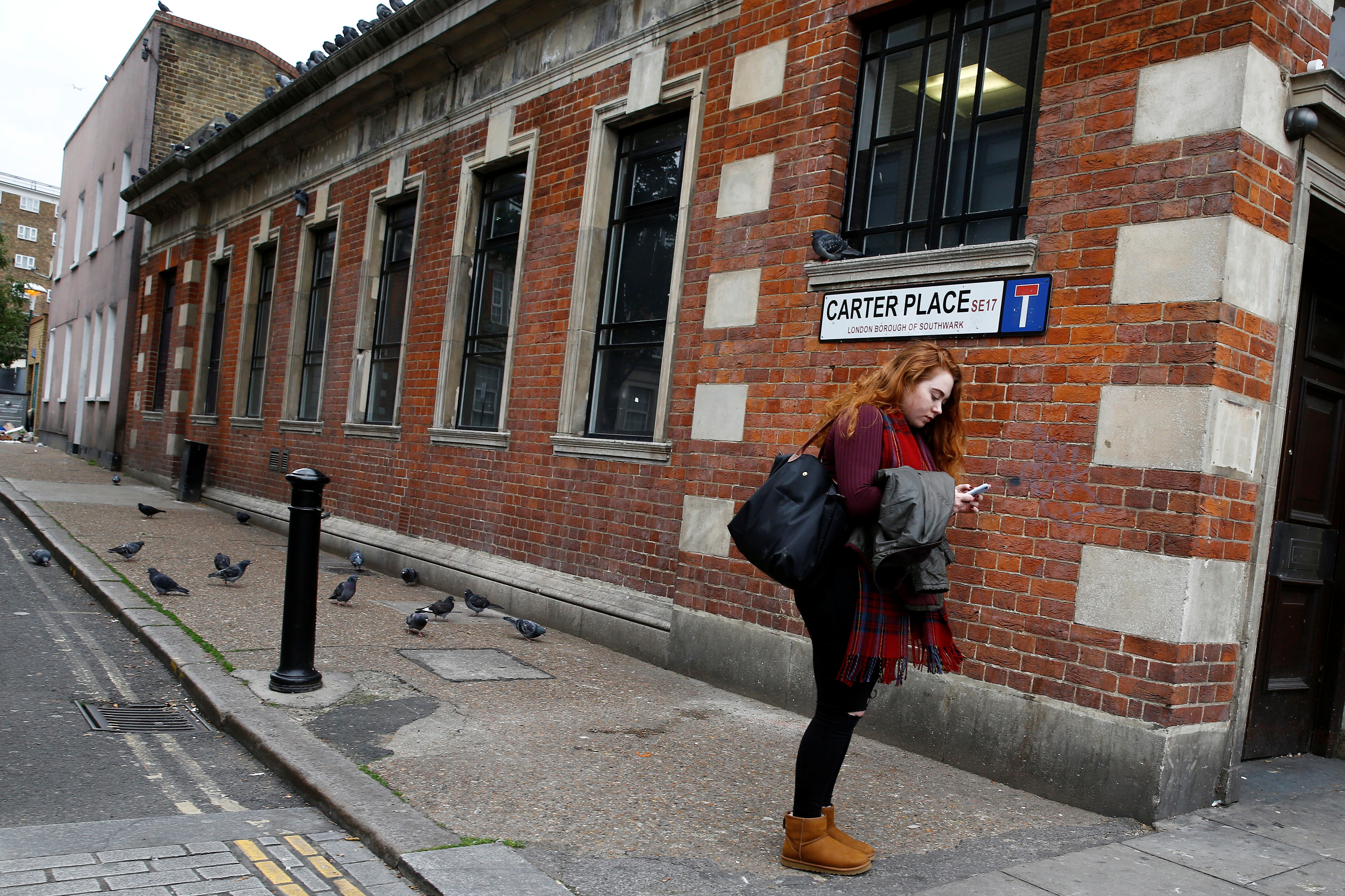 A woman looks at her mobile phone in Walworth, London, Britain October 19, 2016. REUTERS/Stefan Wermuth SEARCH "WERMUTH PHONES" FOR THIS STORY. SEARCH "THE WIDER IMAGE" FOR ALL STORIES. - RC1CA5E061B0