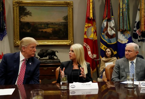 U.S. President Donald Trump listens to Attorney General Pam Bondi (R-FL), center, as Attorney General Jeff Sessions listens, during a meeting with local and state officials about improving school safety at the White House in Washington, U.S., February 22, 2018. REUTERS/Leah Millis - RC11FC38F480