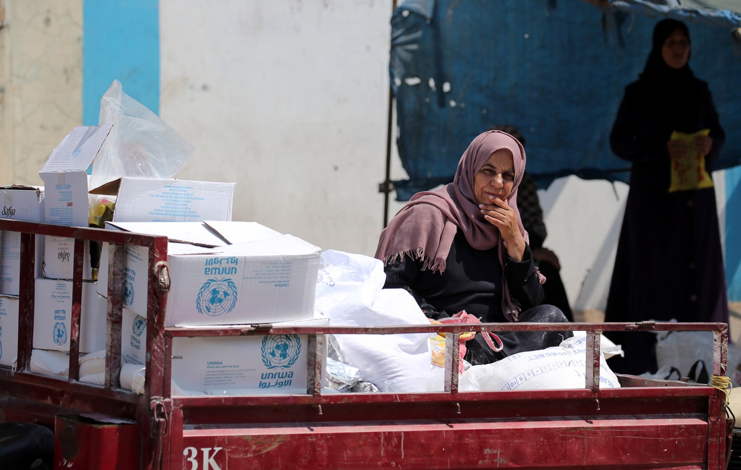 A Palestinian woman sits in a motorised vehicle loaded with aid, outside a distribution center run by the United Nations Relief and Works Agency (UNRWA), in Khan Younis in the southern Gaza Strip September 4, 2018. REUTERS/Ibraheem Abu Mustafa - RC1A87FA4580