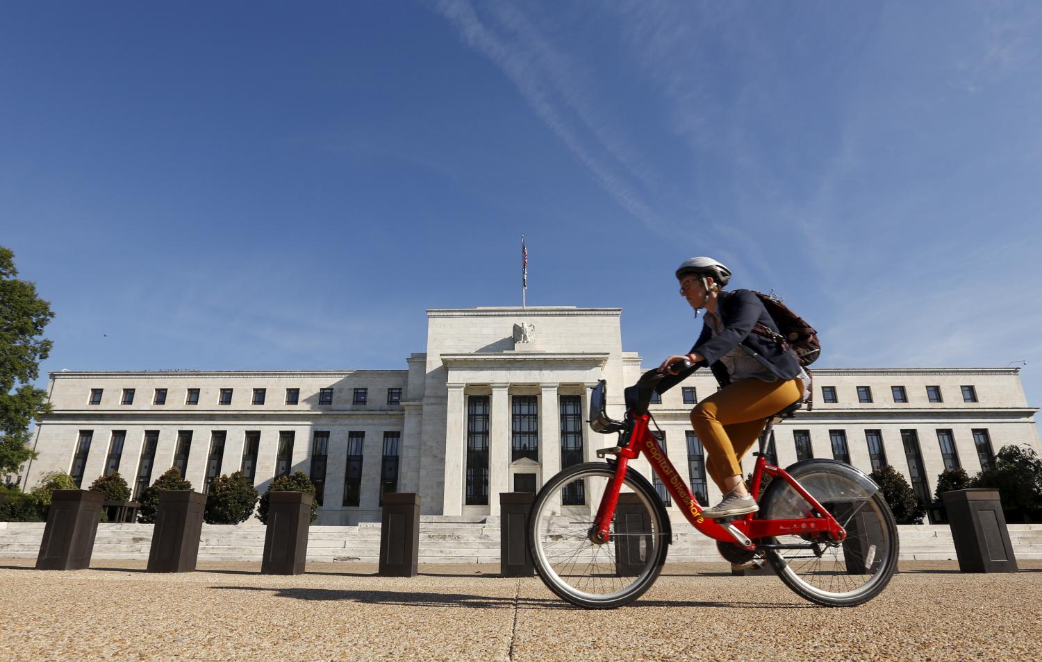 A cyclist passes the Federal Reserve headquarters in Washington September 16, 2015. REUTERS/Kevin Lamarque