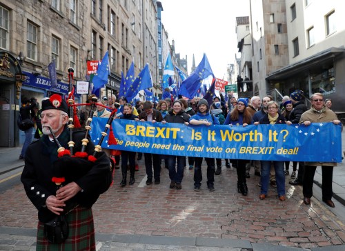 A piper leads protesters waving Saltires and EU flags as they take part in a demonstration to demand a vote on the Brexit deal between Britain and the European Union in Edinburgh, Scotland, March 24, 2018. REUTERS/Russell Cheyne - RC13724D73C0
