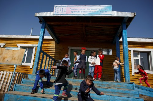 Pupils leave the village school in Tsagaannuur, Khovsgol aimag, Mongolia, April 23, 2018. People who are between 35-40 years old, belong to the last generation that speak the Dukhan language, linguist Elisabetta Ragagnin said. Together with the head teacher of the school in Tsagaannuur, she is writing grammar and textbooks in the nomad's native tongue to help preserve traditional knowledge, she said. REUTERS/Thomas Peter    SEARCH "REINDEER HERDERS" FOR THIS STORY. SEARCH "WIDER IMAGE" FOR ALL STORIES. - RC13671A99A0