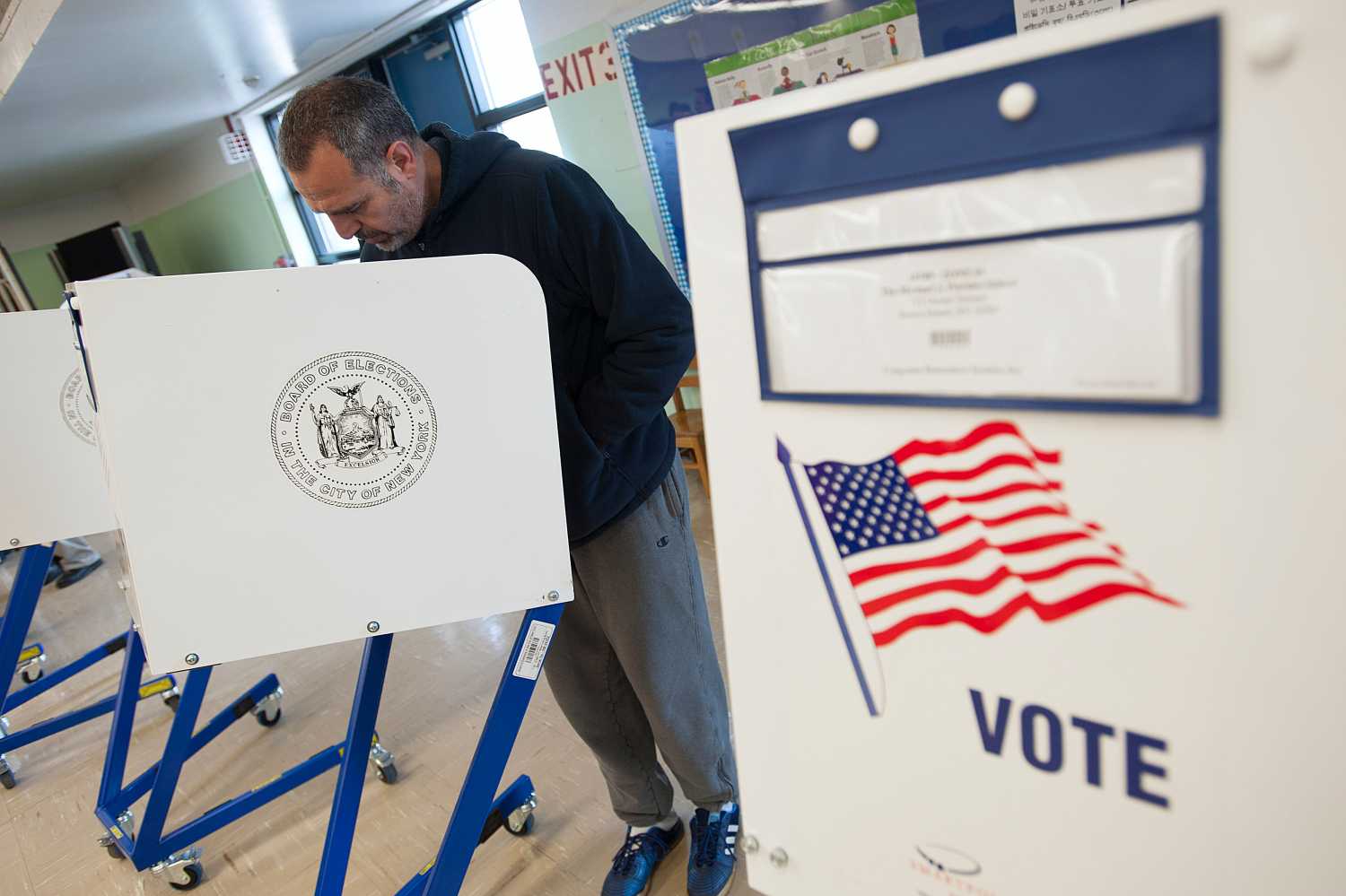 A voter casts his ballot behind a ballot booth during the U.S. presidential election at a polling station in the Staten Island Borough of New York, U.S. on November 6, 2012. REUTERS/Keith Bedford/File Photo - TM3EC7H11OV01