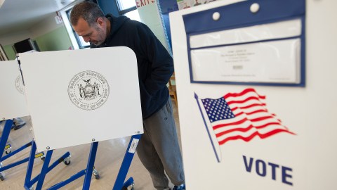 A voter casts his ballot behind a ballot booth during the U.S. presidential election at a polling station in the Staten Island Borough of New York, U.S. on November 6, 2012. REUTERS/Keith Bedford/File Photo - TM3EC7H11OV01