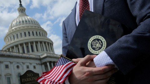 FILE PHOTO: A congressional aide holds flags to give to participants at rally at the U.S. Capitol in Washington, U.S. May 21, 2018.  REUTERS/Jonathan Ernst/File Photo - RC136D9C88F0
