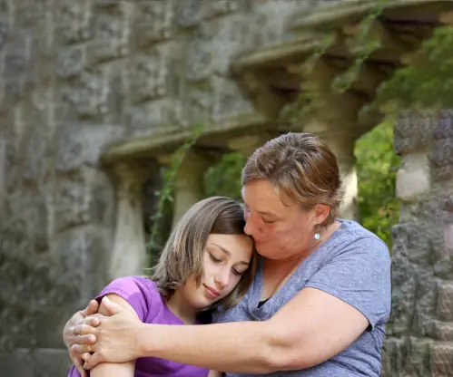 Mother consoling her teenage daughter.