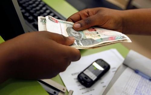 A customer conducts a mobile money transfer, known as M-Pesa, inside the Safaricom mobile phone care centre in the central business district of Kenya's capital Nairobi July 15, 2013. To match Insight AFRICA-MOBILEMONEY/  Picture taken July 15, 2013. REUTERS/Thomas Mukoya (KENYA - Tags: BUSINESS TELECOMS) - GM1EA7U1QS601