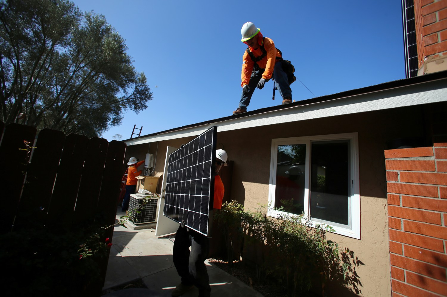 Workers lift a solar panel onto a roof during a residential solar installation in Scripps Ranch, San Diego, California, U.S. October 14, 2016. Picture taken October 14, 2016.       REUTERS/Mike Blake - S1AEUJDNLIAD