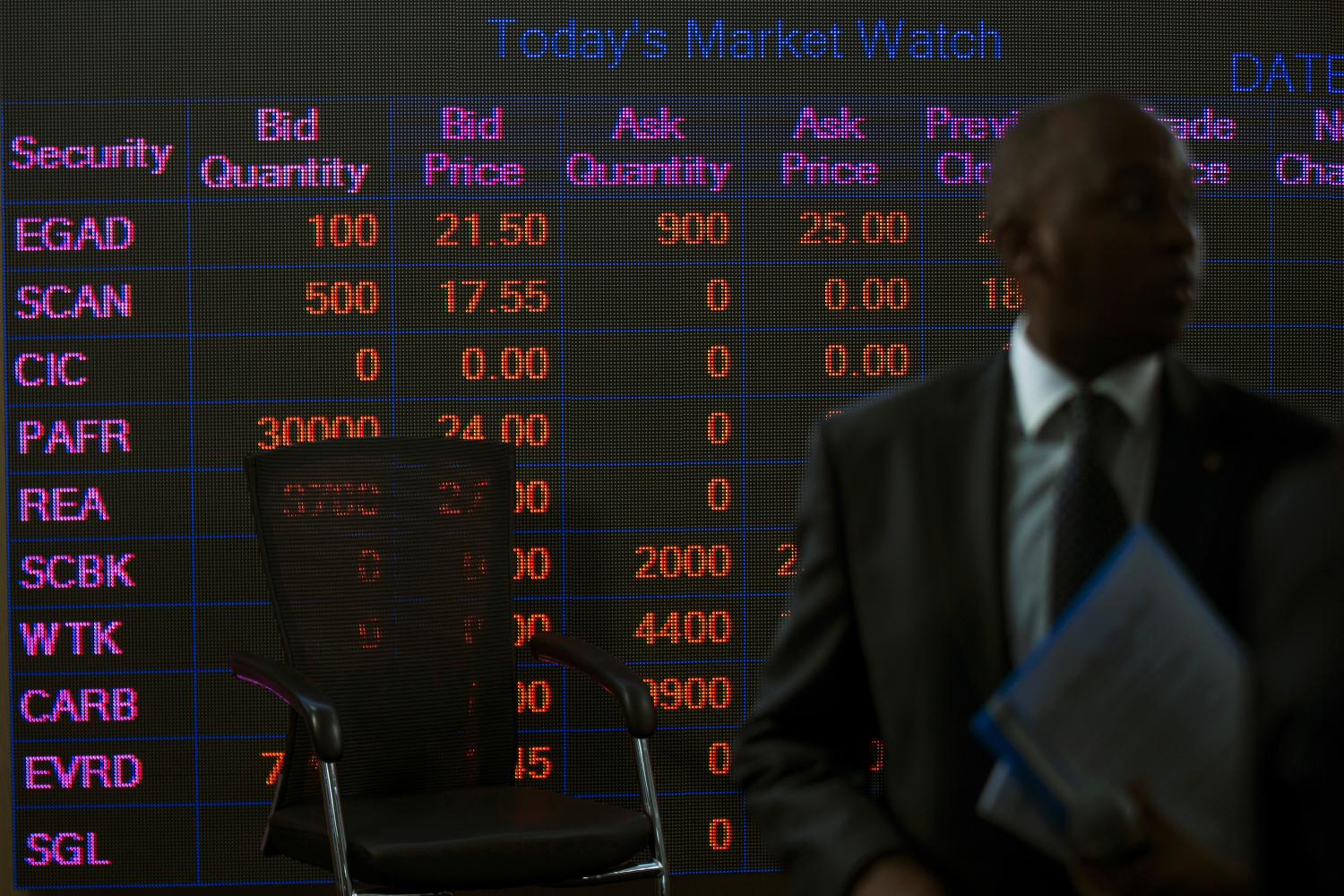 A man stands in front of an electronic board displaying market data at the Nairobi Securities Exchange in Nairobi, Kenya April 11, 2017. REUTERS/Baz Ratner - RC164D4FAF40