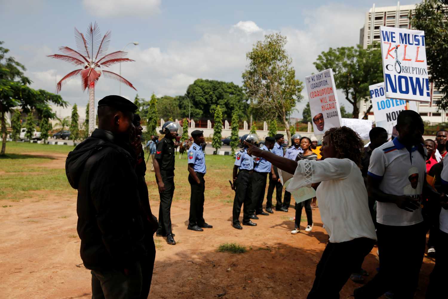 A supporter of President Muhammadu Buhari points at police officers during a rally in support of his administration at the Unity fountain in Abuja, Nigeria August 11, 2017. REUTERS/Afolabi Sotunde - RC18B7A0A160
