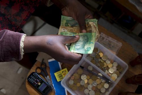 A shopkeeper counts out change above her cash box at her shop in Hillcrest, west of Durban, South Africa, January 11, 2016. REUTERS/Rogan Ward - GF20000091197