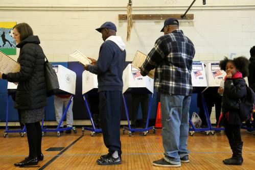 A girl waits in line as voters line up with their ballots at a polling station on election day in Harlem, New York, U.S., November 8, 2016. REUTERS/Bria Webb        - S1AEULRLYVAA