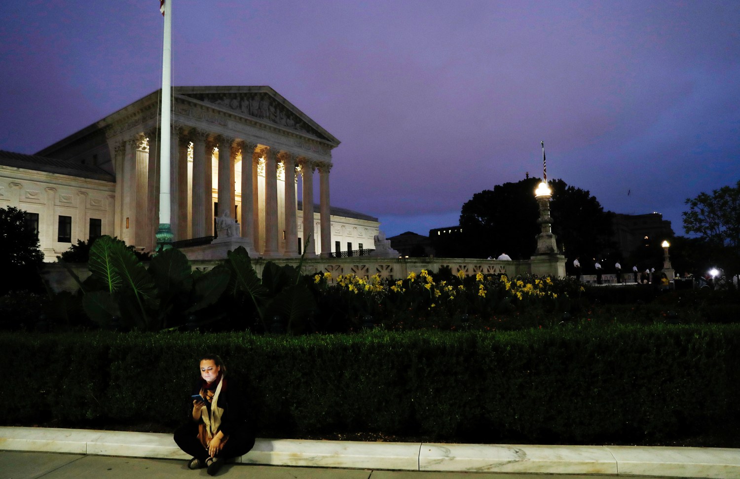 A lone woman sits outside the U.S. Supreme Court building after Justice Brett Kavanaugh was sworn in as an Associate Justice of the court inside on Capitol Hill in Washington, U.S., October 6, 2018.  REUTERS/Carlos Barria - RC13DDDC1740