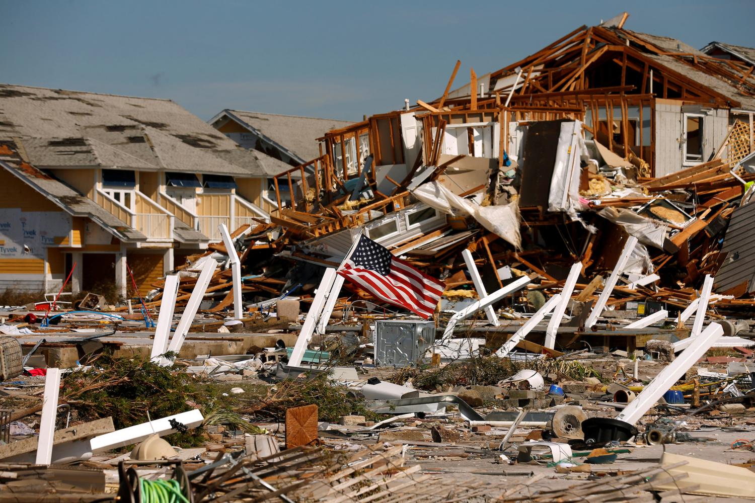 An American flag flies amongst rubble left in the aftermath of Hurricane Michael in Mexico Beach, Florida, U.S. October 11, 2018. REUTERS/Jonathan Bachman     TPX IMAGES OF THE DAY - RC13AB293780