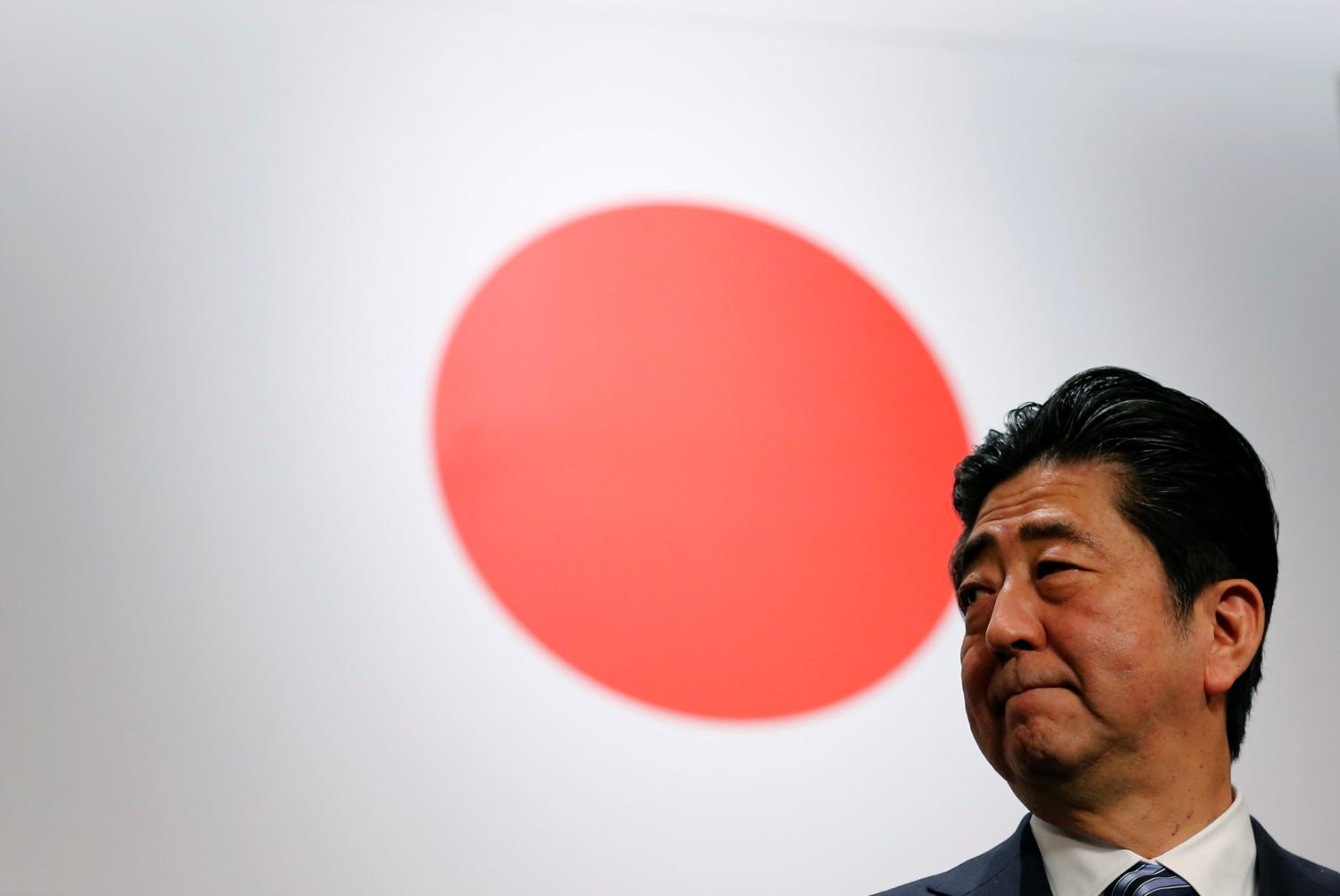 Japan's Prime Minister Shinzo Abe stands in front of Japan's national flag after his ruling Liberal Democratic Party's (LDP) annual party convention in Tokyo, Japan, March 5, 2017.  REUTERS/Toru Hanai - RC1EEE131EC0