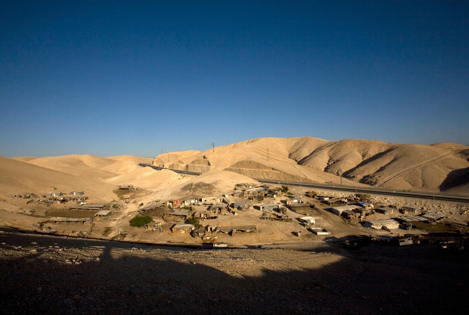 Makeshift structures are seen at a bedouin encampment south of the West Bank Jewish settlement of Mishor Adumim in the Judean Desert August 19, 2009. Many bedouins living in Israel and the occupied West Bank retain a traditional and nomadic way of life, raising livestock and farming arid land.  REUTERS/Ronen Zvulun (WEST BANK POLITICS SOCIETY) - GM1E58K00LD01