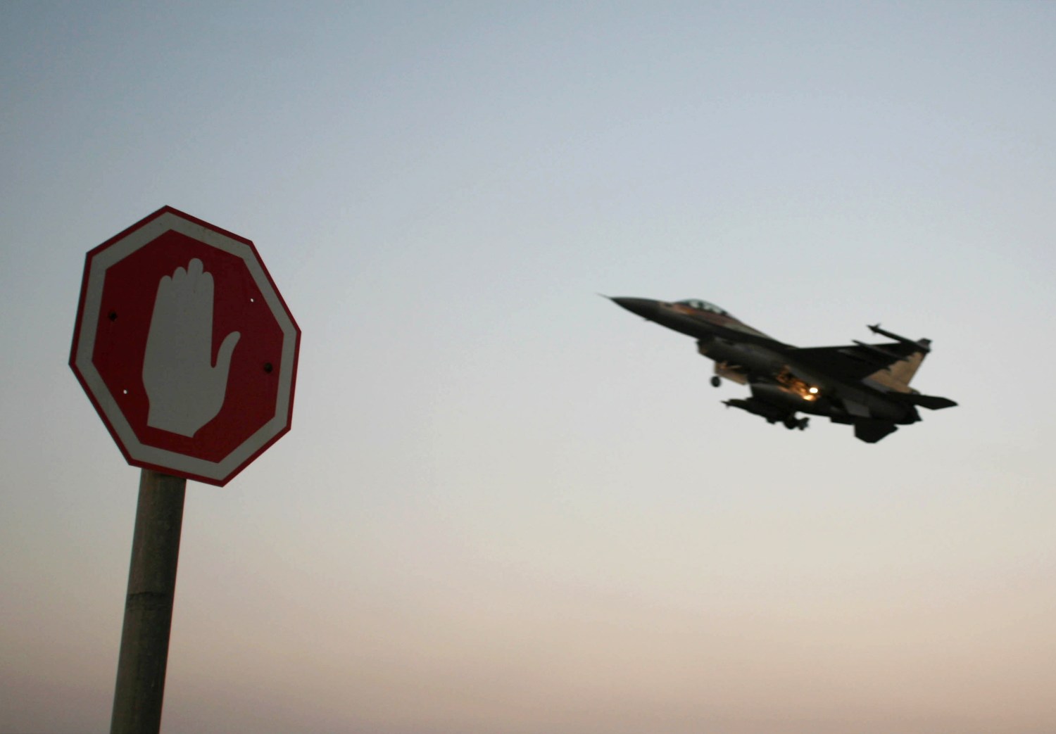 An Israeli Air Force F-16 fighter plane flying above a traffic sign after taking off for a mission in Lebanon from an Israeli Air Force Base in northern Israel in this July 20, 2006 file photo. Israeli warplanes bombed unidentified Syrian targets early on September 6, 2007, causing no damage or casualties, the official Syrian news agency said. Syrian air defences fired at the incoming planes, which crossed into Syria after midnight local time, the agency said. REUTERS/Ammar Awad/Files (ISRAEL) - GM1DWCBQYXAA