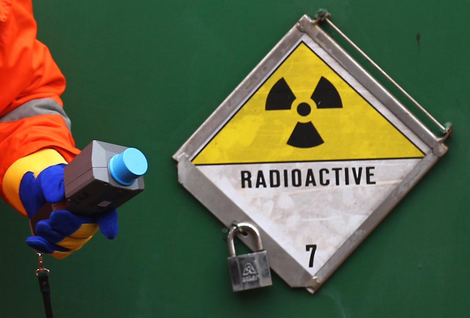 A German police officer uses a Geiger counter to measure the radiation of a Castor container on a transport train, during a stop in Neunkirchen near Saarbruecken November 25, 2011. The Castor (Cask for Storage and Transport Of Radioactive material) train is carrying 11 containers of spent German nuclear fuel on route from France after being reprocessed, to the nuclear waste storage facility of Gorleben in north eastern Germany. REUTERS/Alex Domanski (GERMANY - Tags: POLITICS ENVIRONMENT) - BM2E7BP15PZ01