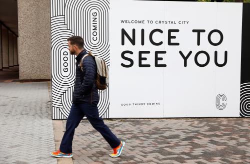 A man passes a sign promoting Crystal City where Amazon announced its new headquarters would be based in Arlington, Virginia, U.S., November 13, 2018. REUTERS/Kevin Lamarque - RC12EAD83090